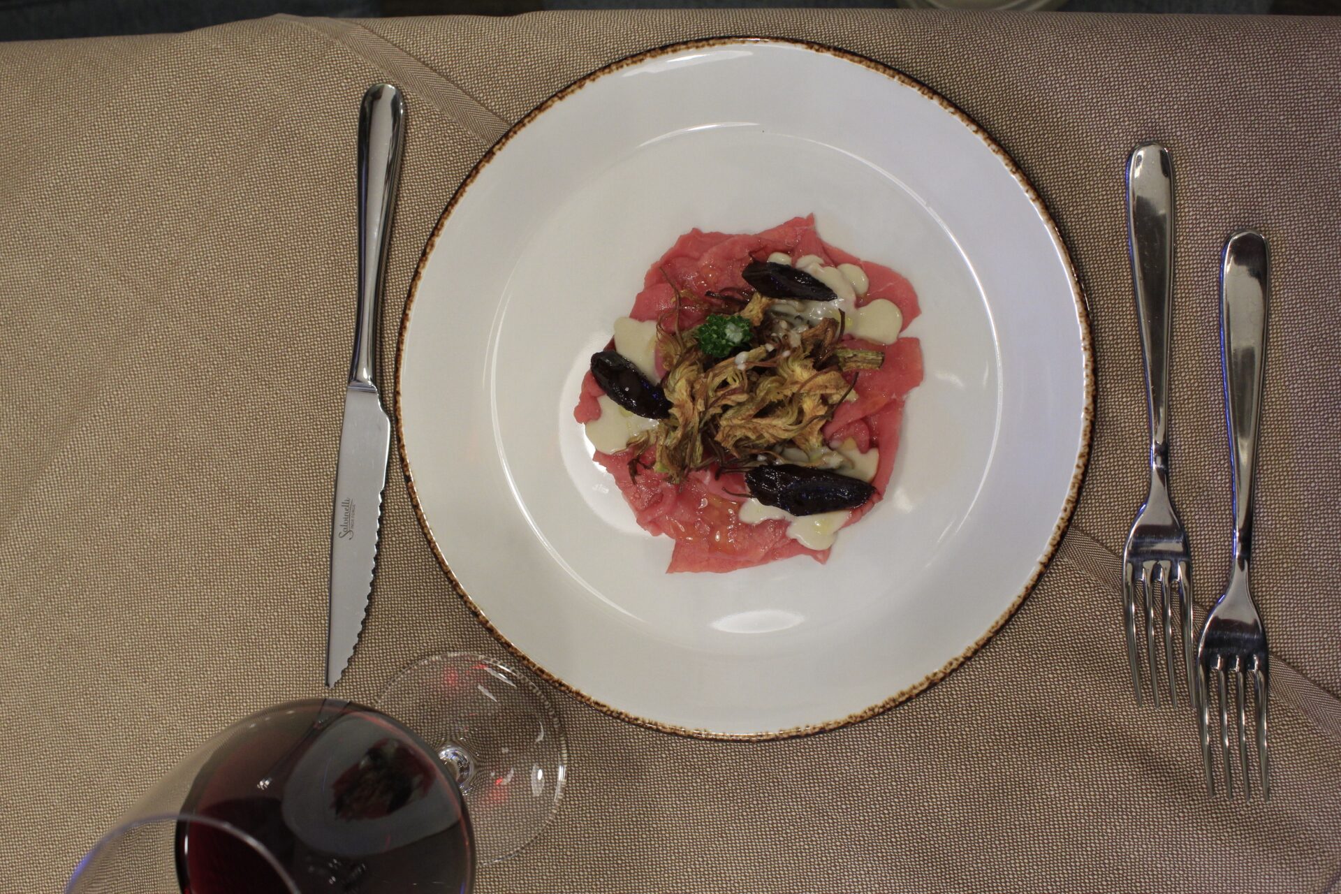Carpaccio di vitello con funghi trifolati e scaglie di formaggio